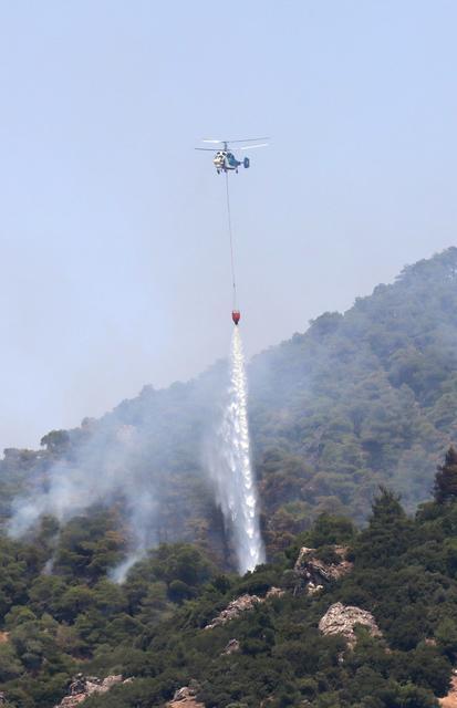 Manisa'nın Turgutlu ile Ahmetli ilçeleri arasındaki ormanlık alanda 3 gün önce çıkan ve dün kısmen kontrol altına alınan yangını söndürme çalışmaları devam ediyor.  ( Ahmet Bayram - Anadolu Ajansı )