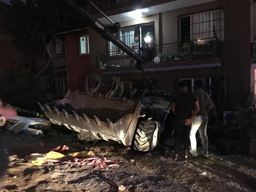 İzmir'in Karabağlar ilçesinde bir apartmanın bahçesine düşen kepçe, 2 evde maddi hasara yol açtı.  ( Yusuf Şahbaz - Anadolu Ajansı )