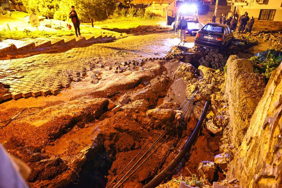 İzmir'deki kuvvetli yağış, su baskınlarına yol açtı. Küçük Çiğli Mahallesi'ndeki parke taşlı 8861 Sokak'ta yol, yağış nedeniyle çöktü. Yolda park halindeki bir otomobilde hasar oluştu.  ( Mehmet Emin Mengüarslan - Anadolu Ajansı )