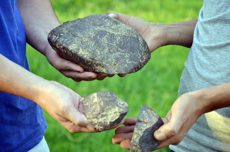 Aydın'da kırsal alanda gezinti yapan Ömer Öztürk ile Emre Can'ın bulduğu taşın "demir meteoridi" olduğu belirlendi. ( Gökhan Düzyol - Anadolu Ajansı )